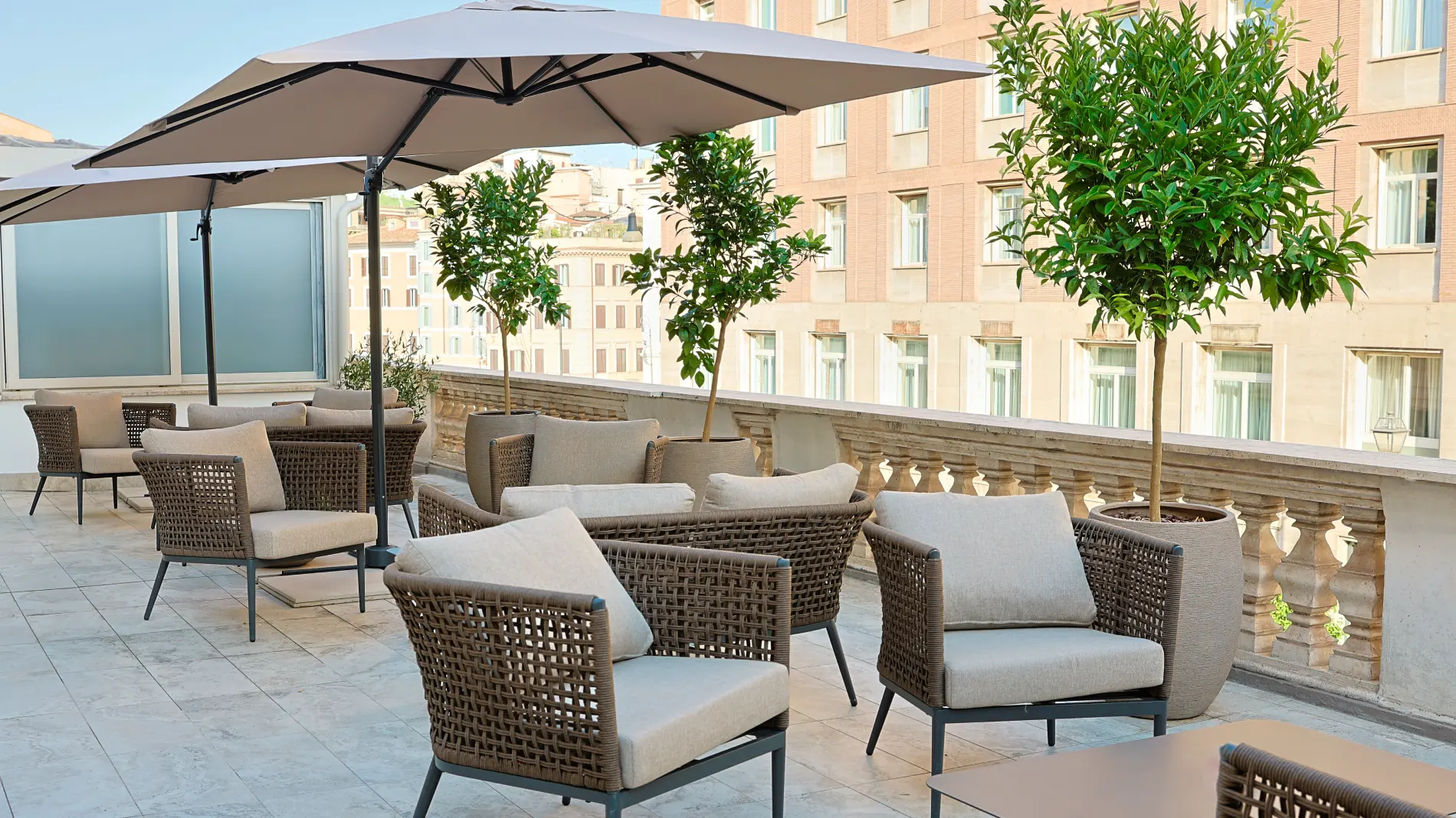 Rooftop terrace lounge area featuring stylish woven cord armchairs and views over Rome. - Barberini 16 Boutique Hotel, BZAR hotels in Rome